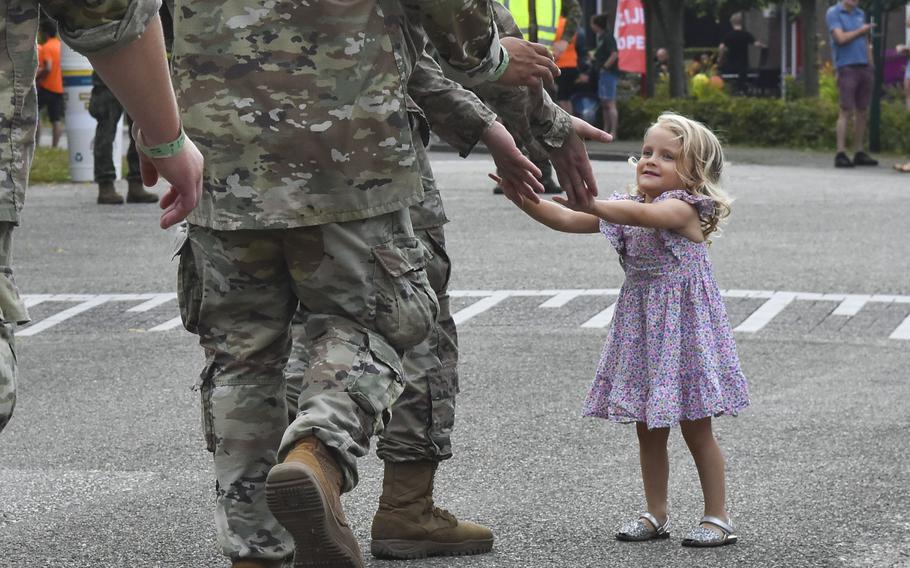 A young girl high-fives U.S. soldiers