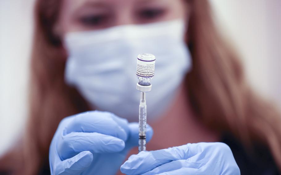 Safeway pharmacist Ashley McGee fills a syringe with the Pfizer COVID-19 booster vaccination at a vaccination booster shot clinic on Oct. 1, 2021, in San Rafael, California. 