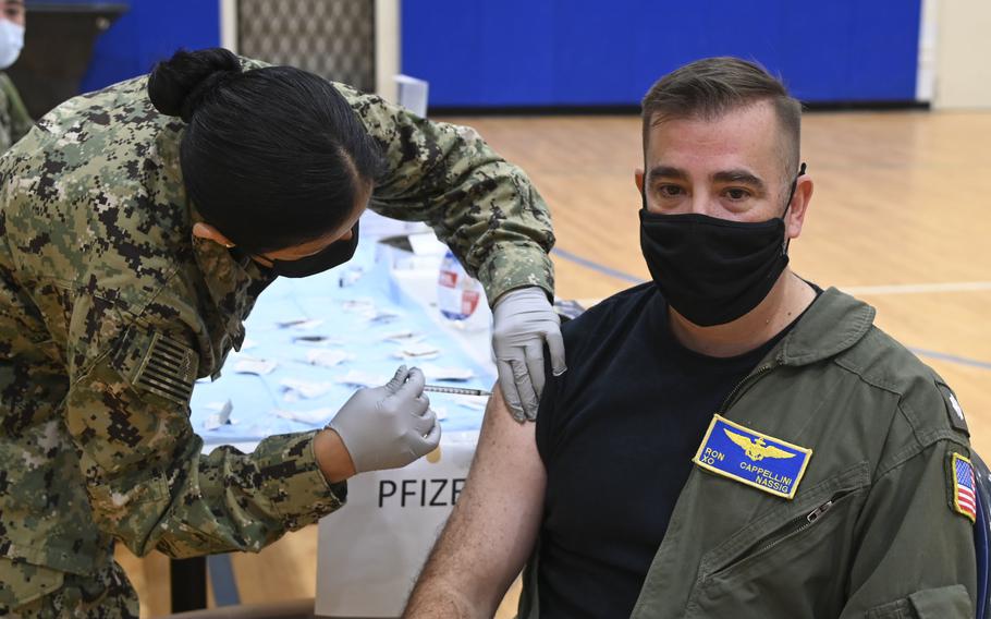 Cmdr. Ronald Cappellini, the Naval Air Station Sigonella executive officer, receives his coronavirus vaccine booster Dec. 7, 2021, from Lt. j.g. Aracely Duerkop during a mass-immunization exercise at the base. 