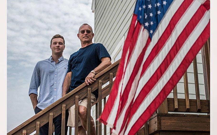 Lt. Adam Will and his father retired Capt. Alex Will, stand on the front steps of the Will home in Hampton, Va. on Thursday, July 6, 2023. Adam is the fourth generation of Navy submariners to hail from the Will family following his father, his grandfather, Capt. John Will Jr., and great-grandfather, 4-star Admiral John Will Sr. 