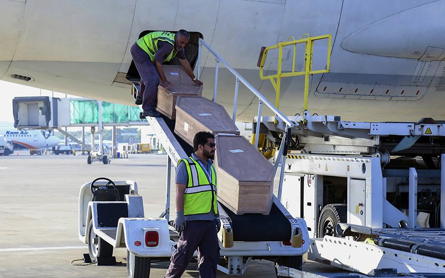 Airport workers unload bodies of Afghans from the Ariana Afghan Airlines at the Kabul International Airport in Kabul, Afghanistan, Wednesday, May 24, 2023. 