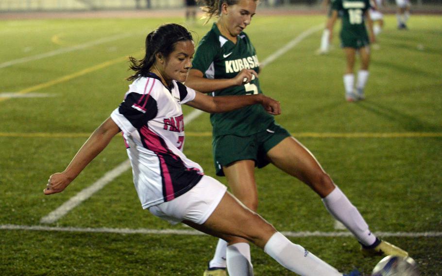 Kadena's Mia Garza and Kubasaki's Megan Chandler tangle for the ball during Wednesday's DODEA-Okinawa soccer match. The Dragons won 3-1.