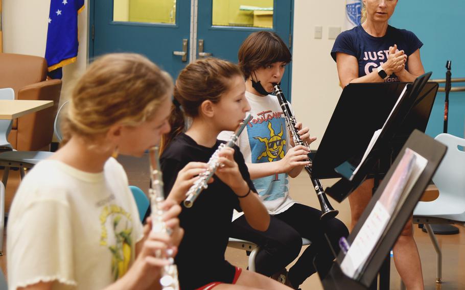 Jenny Gaume, music teacher at Yokota High School, teaches, from left, students Sydney Roddan, Molly Bogdon and Jay Mahone the marching band the song "Mic Drop," by BTS at Yokota High School on Yokota Air Base, Japan, Aug. 9, 2022.