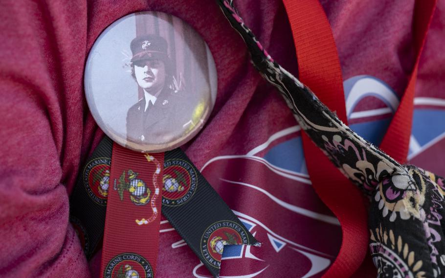 A pin with a photo of a female service member is shown on a shirt