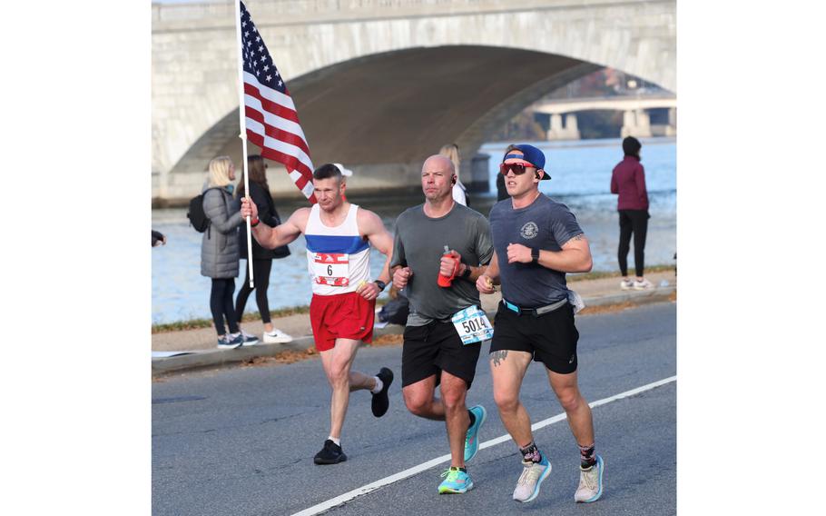 A runner carries the colors during the Marine Corps Marathon on Sunday, Oct. 30, 2022, in Arlington, Va.