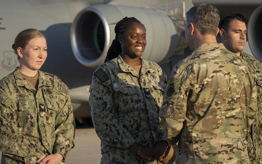 A general shakes hands with sailors.
