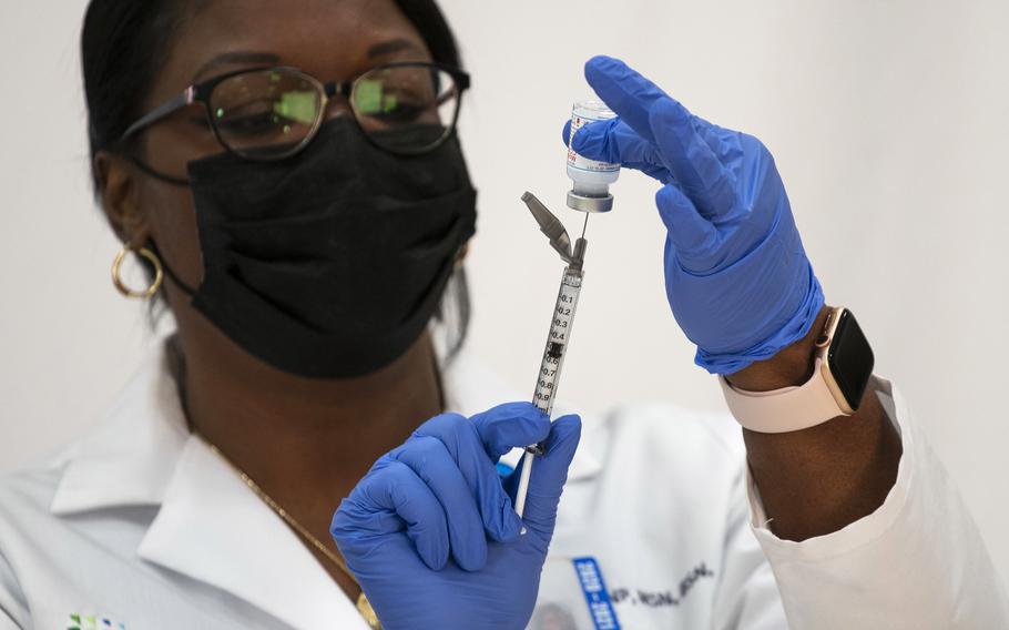 In this Dec. 21, 2020, photo, Michelle Chester, director of employee health services at Northwell Health, prepares the Moderna COVID-19 vaccine at Northwell Health's Long Island Jewish Valley Stream hospital in Valley Stream, N.Y. Hospitals and nursing homes across the country are preparing for worsening staff shortages as state deadlines arrive for employees to get vaccinated against COVID-19. 