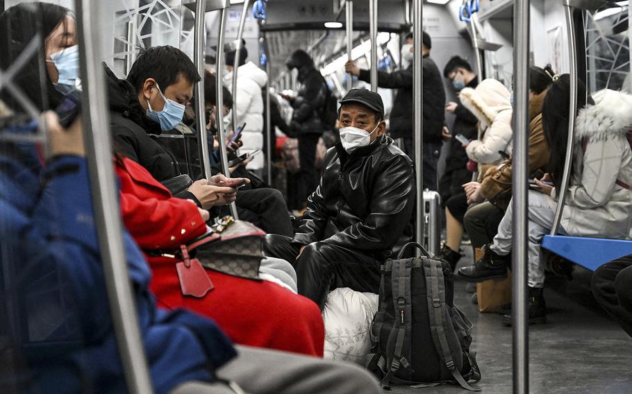 People on a train in Beijing wearing face masks during the COVID pandemic.