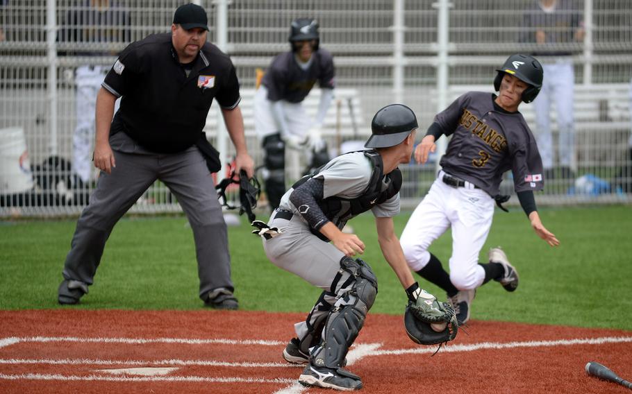 Kubasaki catcher Ryder Beaudoin turns to tag out American School In Japan's Kento Yan during Friday's inter-district baseball game. The Dragons edged the host Mustangs 2-1.