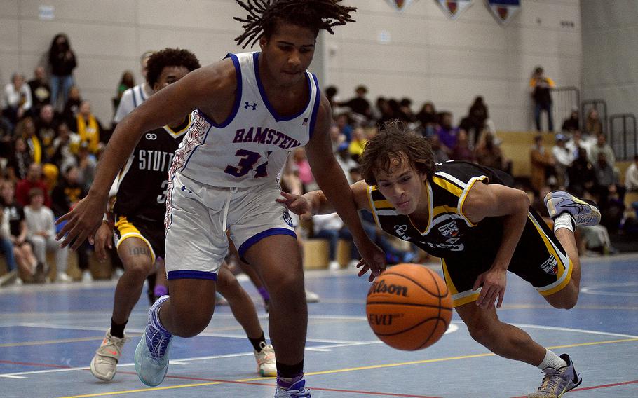 Ramstein's Tyrell Edwards and Stuttgart's Ryan Stevenson fight for a ball during a basketball game on Dec. 8, 2023, at Ramstein High School on Ramstein Air Base, Germany.