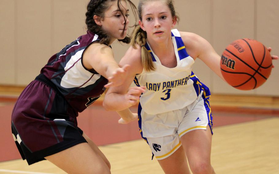 Yokota's Charlotte Rhyne drives againsst Matthew C. Perry's Cambria Villanueva during Saturday's DODEA-Japan girls basketeball game. The Panthers won 42-27.