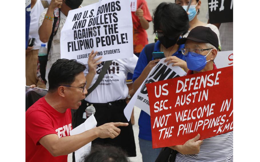 Protesters display placards and burn a mock US  flag to protest the visit of US Defense Secretary Lloyd Austin to the Philippines Thursday, Feb. 2, 2023, at Camp Aguinaldo in suburban Quezon city northeast of the capital Manila. 