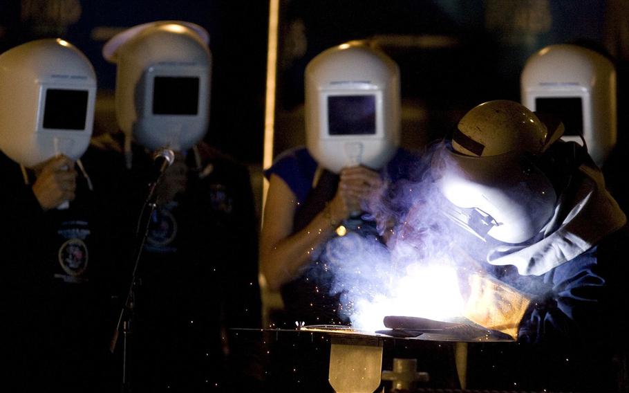 Robert Bowker welds the initials of the ship's sponsor, Susan Ford Bales onto the keel Saturday, Nov. 14, 2009, during the keel laying and authentication ceremony for the Gerald R. Ford carrier (CVN 78) at Northrop Grumman Corp.'s Newport News shipyard.