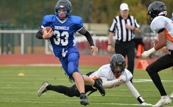 Brussels’ William Pierce gets past a pair of Spangdahlem defenders on his way to a touchdown in the DODEA-Europe Division III football final in Kaiserslautern, Germany, Oct. 29, 2022. Brussels won 64-48.