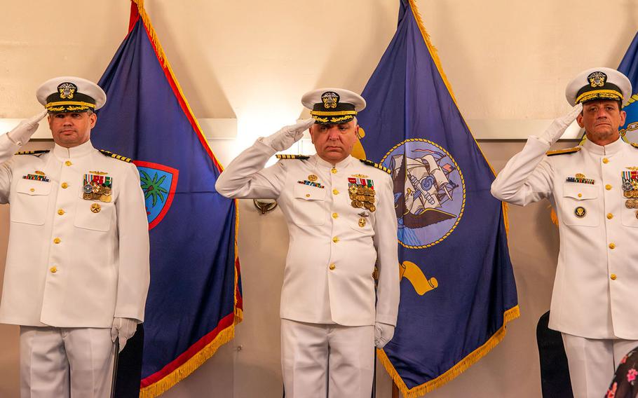 Capt. John Frye, left, Capt. Michael Luckett, center, and Rear Adm. Greg Huffman, commander of Joint Region Marianas, stand at attention during a change-of-command ceremony for Naval Base Guam, Jan. 26, 2024.
