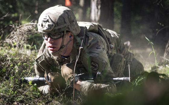 Pfc. Matthew Simpson of the 41st Field Artillery Brigade low-crawls during the V Corps Best Squad Competition at Grafenwoehr Training Area, Germany, on May 12, 2025.
