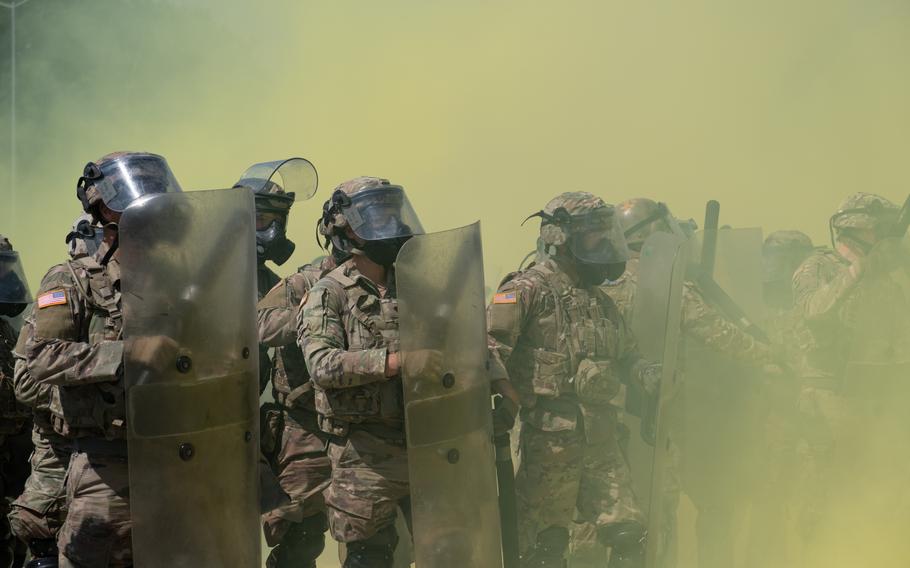 Riot control forces close in during the Operation Bronze Shield training exercise June 14, 2023, at the Joint Multinational Training Center in Hohenfels, Germany. Personnel from the training center used smoke grenades during the simulation. Exercise participants are preparing to rotate into Kosovo.  
