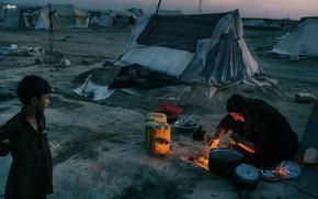 A woman prepares dinner on a campfire in the Shedai displaced persons camp outside the city of Herat, Afghanistan, in March. MUST CREDIT: Photo for The Washington Post by Lorenzo Tugnoli.