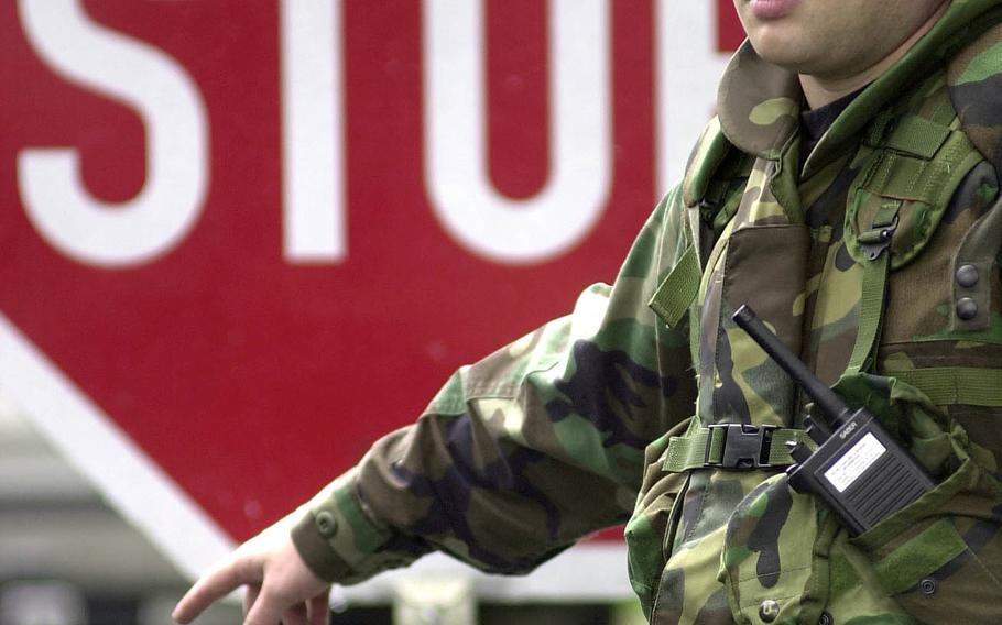 An airman from the 469th Security Forces Flight directs cars approaching Rhein-Main Air Base, Germany, to stop for a search on Sept. 12, 2001.