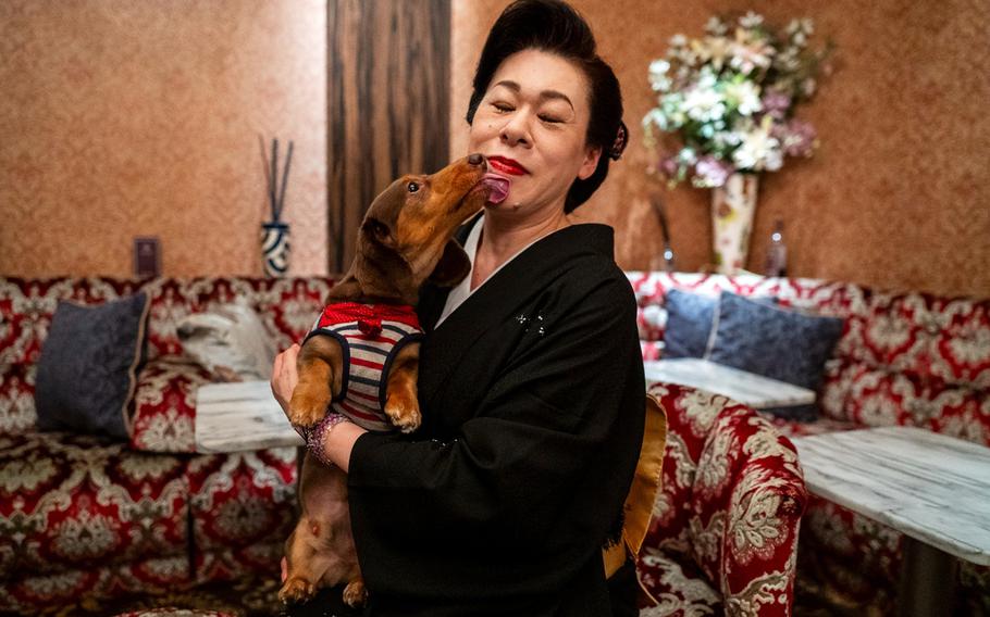 A restaurant and bar owner poses for a portrait with her dog in Tokyo, May 23, 2025.