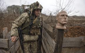 A Ukrainian soldier walks in a trench at the line of separation from pro-Russian rebels, Donetsk region, Ukraine, Sunday, Jan. 9, 2022. (AP Photo/Andriy Dubchak)