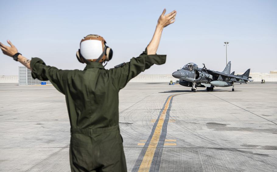 Lance Cpl. Jarod Volstorf, 11th Marine Expeditionary Unit, signals to an AV-8B Harrier pilot at Al Udeid Air Base, Qatar, Nov. 28, 2021. An estimated 40,000 to 60,000 troops are deployed to Central Command, according to a recent statement from the command to Stars and Stripes.