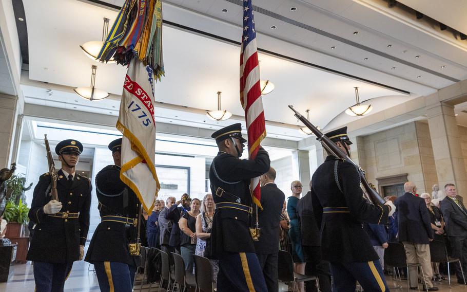 Color Guard marches holding flags and rifles.