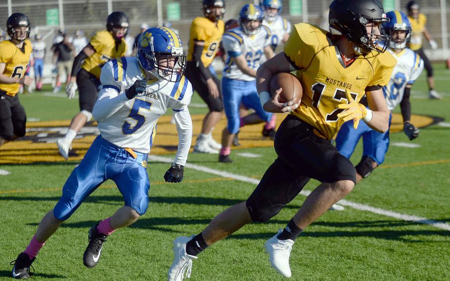 American School In Japan's James Curtis turns on ths speed to try to avoid Yokota defender Michael Kasten.