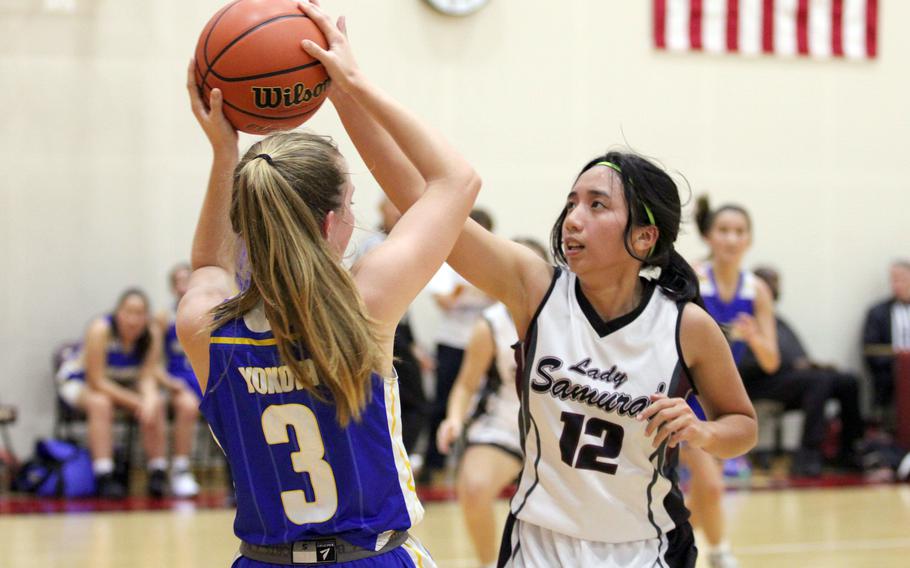 Matthew C. Perry's Aiya Versoza defends against Yokota's Charlotte Rhyne during Friday's DODEA-Japan season-opening girls basketball game. The Samurai won 32-29 for their first victory since Feb. 8, 2020.