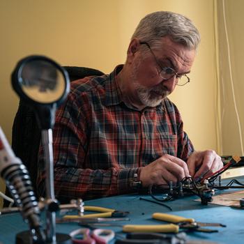 Ivan Bilodid, 65, builds an FPV drone in his home in Moschun, Ukraine. Russian troops lived in his home during their occupation. Now he makes drones to send to the Ukrainian military.