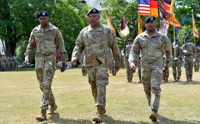 U.S. Army Europe and Africa commander Gen. Darryl Williams is flanked by the outgoing commander of the 21st Theater Sustainment Command, Maj. Gen. James Smith, left, and the incoming commander, Brig. Gen. Ronald Ragin, as they march off the field in Kaiserslautern, Germany, on Wednesday, June 7, 2023.