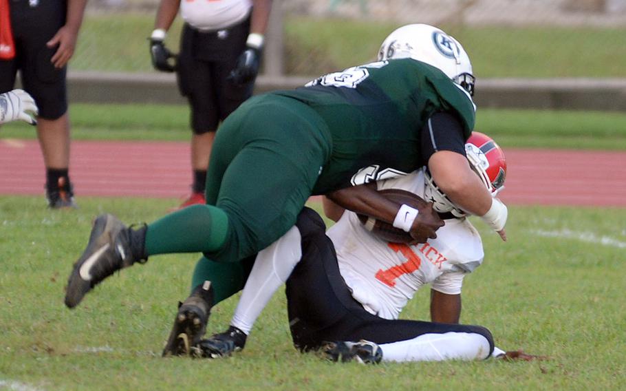 Kubasaki's Anthony Finegan brings down Nile C. Kinnick quarterback Josiah Chambers.