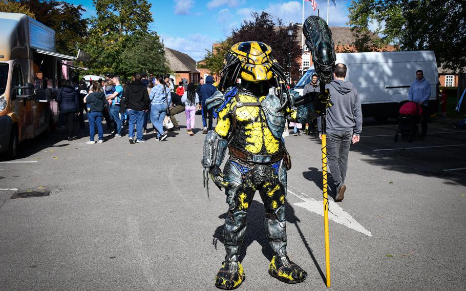 A costumed fan of the Predator movie franchise stands for photos at Mil-D-Con at RAF Mildenhall, England, on Oct. 1, 2022.