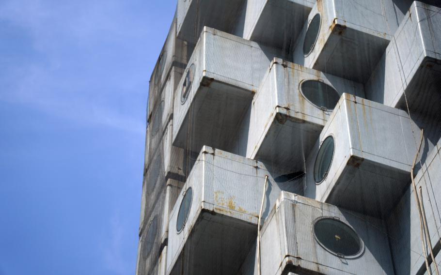 Netting covers the iconic Nakagin Capsule Tower in Tokyo's Ginza district, Tuesday, April 12, 2022. 