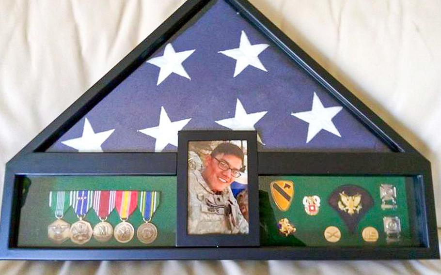 A photo of Army Spc. Zachary Moore, 23, who died by suicide on Aug. 2, 2017, the flag that was draped over his coffin and his military shadow box kept as a memorial by his mother, Jeanette Nazario.