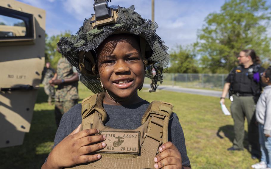 A student at Oaks Road Academy poses for a photo next to a Joint Light Tactical Vehicle in New Bern, N.C., Friday, April 19, 2024. 