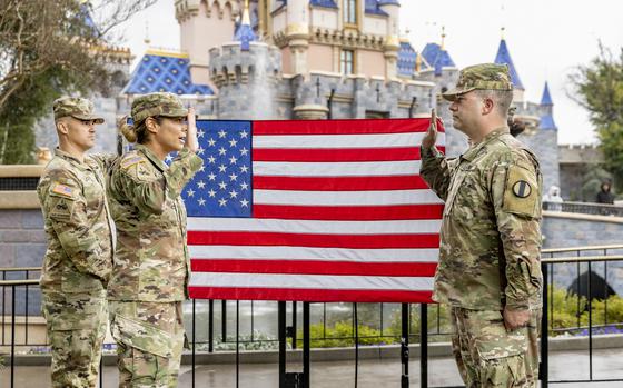 Maj. Roxy Thompson, officer-in-charge of Defense Media Activity’s Army Productions, conducts the formal reenlistment of Sgt. 1st Class Nick Nofziger at Disneyland park on Feb. 19, 2024. 