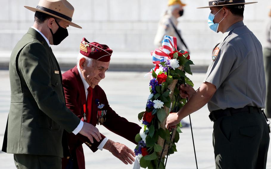 World War II veteran Harold Radish, center, and Superintendent of the National Mall and Memorial Parks Jeffrey Reinbold place a wreath during a Memorial Day ceremony at the National World War II Memorial in Washington, D.C., May 31, 2021.