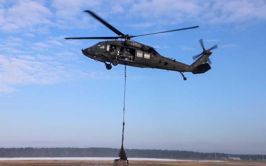 U.S. Army soldiers practice hooking up a sling load to a UH-60 Black Hawk helicopter, at Powidz, Poland, on Nov. 30, 2023. A recent agreement between Washington and Warsaw calls for Poland to upgrade facilities used by U.S. forces in the country, including a $35 million rotary wing apron at Powidz.