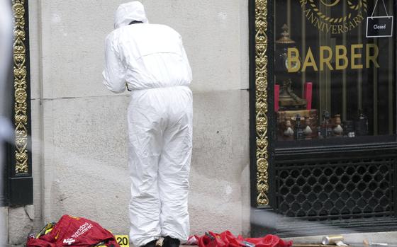 A Forensic officer looks at evidence near the site where a 53-year-old British man plowed a minivan into a crowd of Liverpool soccer fans who were celebrating the city's Premier League championship Monday, injuring more than 45 people in Liverpool, England, Tuesday, May 27, 2025.(AP Photo/Jon Super)