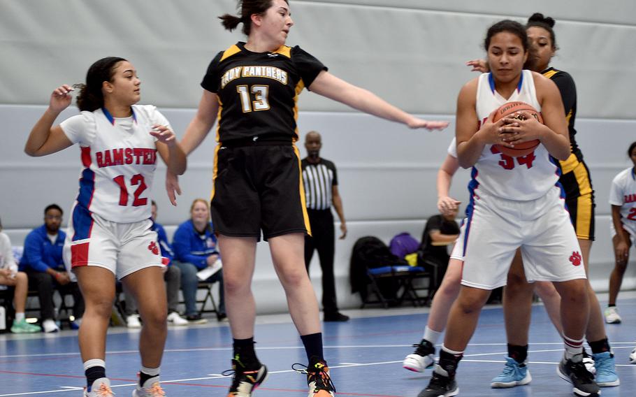 Ramstein's Alysha Edwards grabs a rebound against Stuttgart's Kinsey Heaton during round-robin action at the Division I DODEA European Basketball Championships on Friday morning at Ramstein High School on Ramstein Air Base, Germany. Also pictured is, at left, the Royals' Parker Ingram.