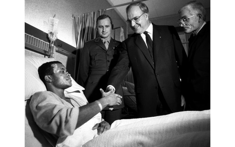 Former German Chancellor Helmut Kohl shakes hands with U.S. Marine Lance Cpl. Kevin Jiggetts, who was wounded in the Oct. 23, 1983, terrorist bombing of a barracks in Beirut, Lebanon. The bombing killed 241 American service members, 220 of them Marines. With Kohl on his visit to the U.S. Air Force hospital in Wiesbaden are Marine liaison officer 1st Lt. Charles Evans and, at right, the chancellor's interpreter.