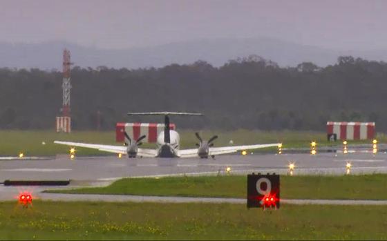 In this image taken from video, a light plane with three people aboard lands safely without landing gear after circling the airport for almost three hours to burn off fuel at Newcastle Airport, Australia, Monday, May 13, 2024.