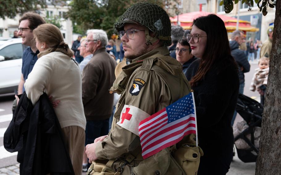 A costumed World War II reenactor watches a parade.