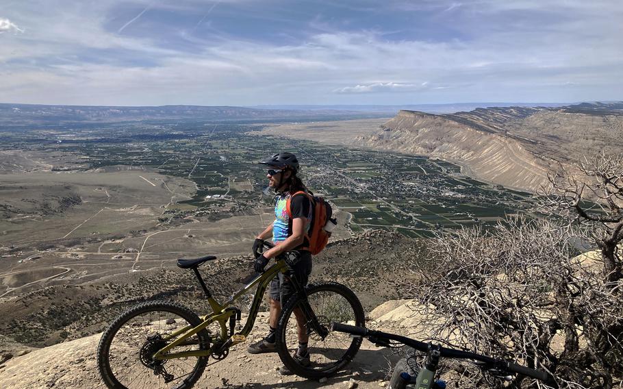 Geoff Roper takes a break above the last major descent of the Palisade Plunge trail in Colorado, with the homes, vineyards, shops and cafes of town visible far below. 