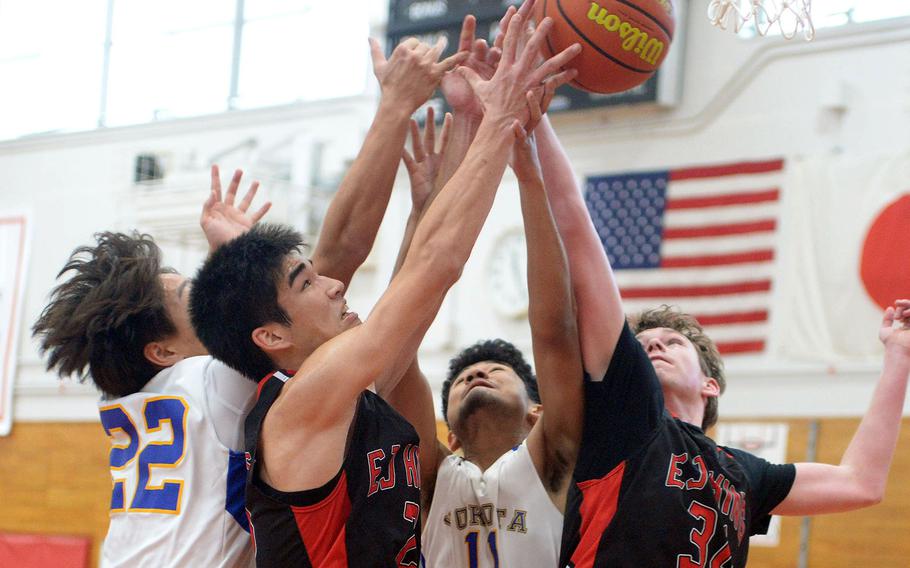 Yokota's Theodore Shone and Kenshin Brown and E.J. King's Nolan FitzGerald and Ben Niefer go up for the rebound during Saturday's DODEA-Japan boys basketball game. The Panthers won 67-57.
