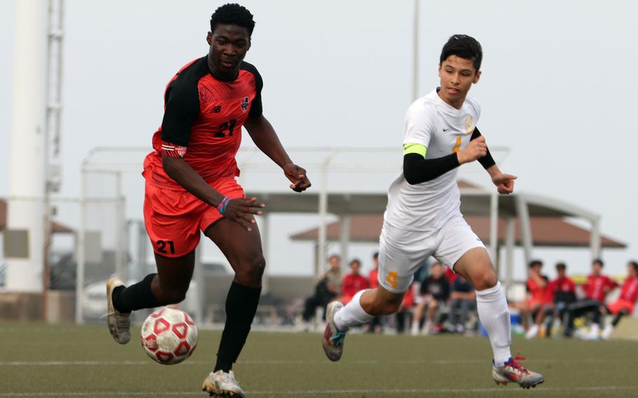 Koboyo Awesso and Alberto Nakamoto follow the ball.