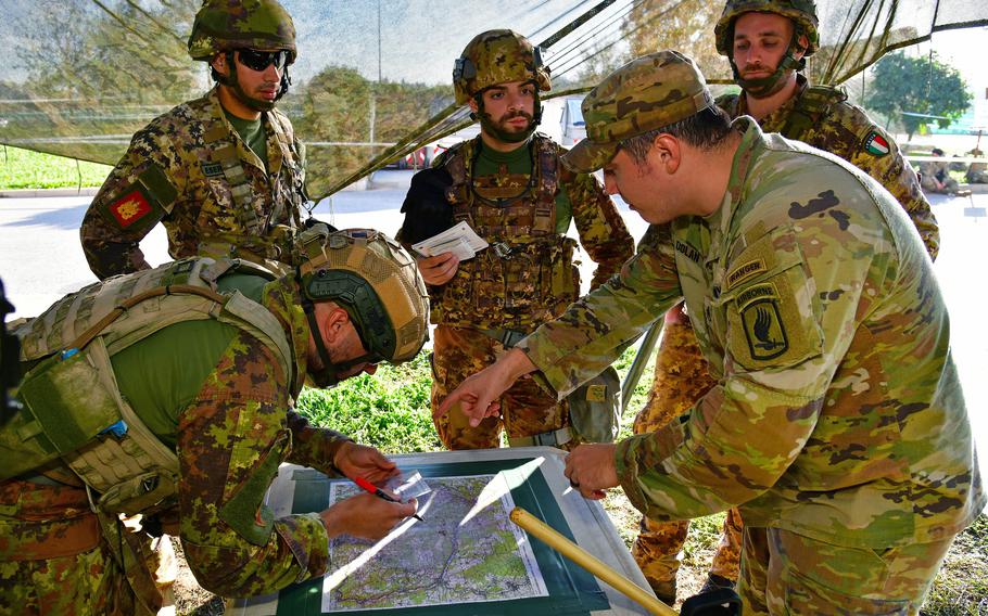 Paratroopers assigned to the U.S. Army’s 173rd Airborne Brigade and Italian army soldiers plot a point on a map for a land navigation event during the weeklong Expert Infantryman Badge, Expert Soldier Badge and Expert Field Medical Badge training at Caserma Del Din, Vicenza, Italy, Oct. 28, 2022.