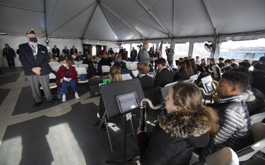 Bernie Kofoet, left, a member of the American Legion FW Grigg Post #68, stands during a “Medley of the Military Hymns” performed by John Stanz, right, and the Eastern High School Band at a Pearl Harbor Day Commemoration ceremony on board the Battleship New Jersey.