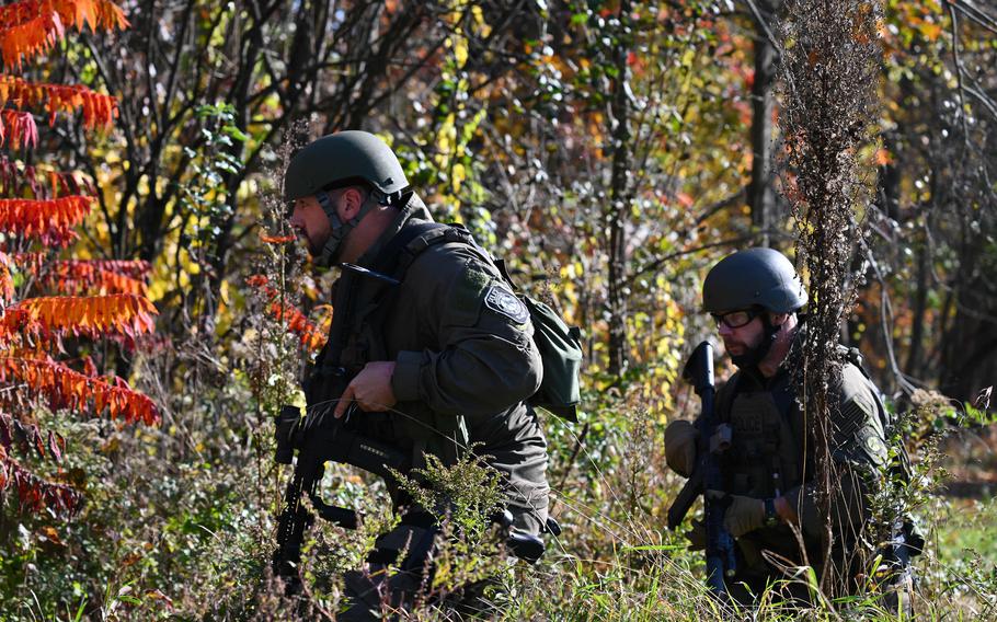 Law enforcement personnel approach a home in Monmouth, Maine, on Oct. 27, 2023, in the aftermath of a mass shooting in Lewiston, Maine. Thousands of anxious small-town Maine residents began a second day under lockdown as police waging a sprawling manhunt struggled to find a U.S. Army reservist accused of killing 18 people in America’s deadliest mass shooting this year.